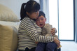 © Bo Bo/Stocksy - crying little boy in his mother's arm indoor