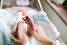 Mom Holds Baby's Feet In Hands