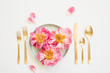 © Kelly Knox/Stocksy - three pink peonies on a plate with gold flatware