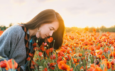 Sticker - Romantic girl smelling a poppy flower in field.