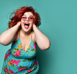 Happy plus-size lady fat woman holds her head with her arms and shouts or loud laughs having good time crazy shopping sale offer