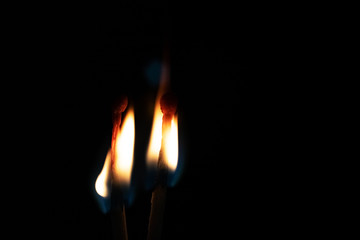 Two burning matches in the dark close up, copy space