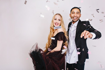 Portrait joyful cute couple in love celebrating great party in tinsels on white background. Luxury evening clothes, happiness, smiling, Valentine s day. Place for text