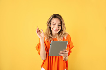 Canvas Print - Woman using tablet for video chat on color background