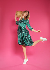 Poster - Full length portrait of emotional woman dancing on color background