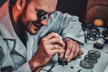 Wall Mural - Expirienced clockmaster is fixing old watch for a customer at his repairing workshop.