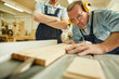 © Seventyfour - Portrait of  carpenter cutting wood using disksaw while working in joinery workshop, copy space