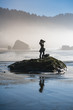 Young girl on beach taking photos of Oregon coast