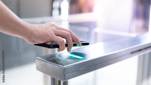 Cuadros en Lienzo Male hand using smartphone to open automatic gate machine in office building