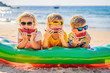 © galitskaya - Children eat watermelon on the beach in sunglasses