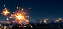 Burning Sparkler With Blurred Bokeh Cities Light Background
