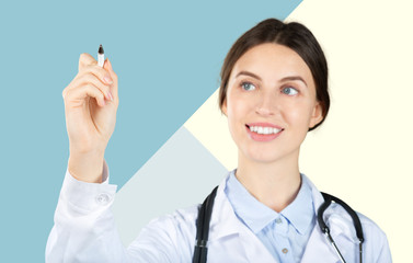 Canvas Print - Smiling female doctor in white coat with stethoscope and clipboard pointing finger