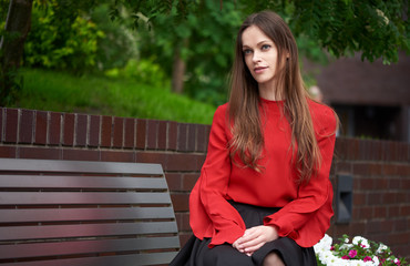 Canvas Print - Beautiful woman sitting on the bench in the city. Summer.