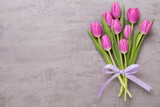 Fototapeta Tulipany - Spring greeting card, pink color tulips on the gray background.