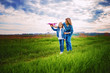 © zamuruev - Young woman and girl in denim clothes having fun with small plane on green lawn in summer day