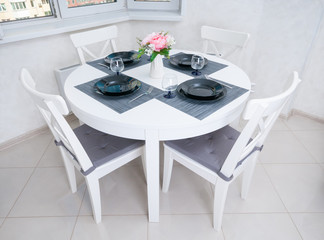 Circle wooden table served for dinner with chairs