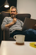 © cherryandbees - man using laptop relaxed in his sofa at his apartment