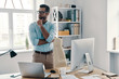 © gstockstudio - Hard decision to make. Young modern businessman keeping hand on chin and looking away while working in the office