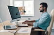 © gstockstudio - Checking annual report. Young modern businessman analyzing data using computer while sitting in the office