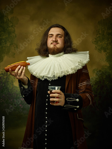 Fotografía Young man as a medieval knight on dark studio background