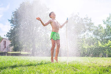 Cute  Preschooler Boy Refresh Herself From Garden Watering Hose On The Family Country House Grass Yard.