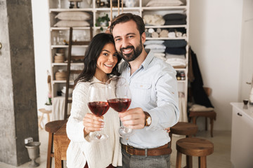 Sticker - Portrait of attractive european couple drinking wine from glasses while having romantic dinner at home