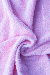 Texture of soft tissue fibers. Close-up.Fluffy Gentle baby fabric with waves and folds. Soft pastel textile texture. Folds on the soft fabric. Rose towel terry cloth.