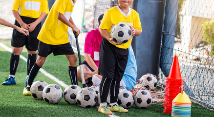 kid soccer ball and soccer training equipment on green artificial turf.