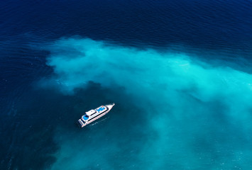 Wall Mural - fast boat at the sea in bali, indonesia. aerial view of luxury floating boat on transparent turquois