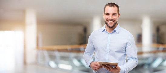 smiling business man in the business center with tablet