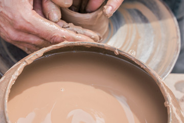 Master teaching  pottery. Working with clay. Master ceramist teaches student. Craftsman hands making pottery bowl. 