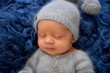 © Oksana - Sleeping newborn boy in the first days of life on blue background