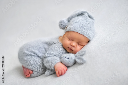 Photographie Sleeping newborn boy in the first days of life on white background