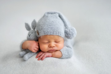 sleeping newborn boy in the first days of life on white background
