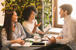 © Prostock-studio - Young multiethnic business team sharing ideas in cafe