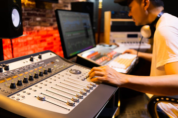 Wall Mural - asian male professional sound engineer working in recording, broadcasting, editing studio