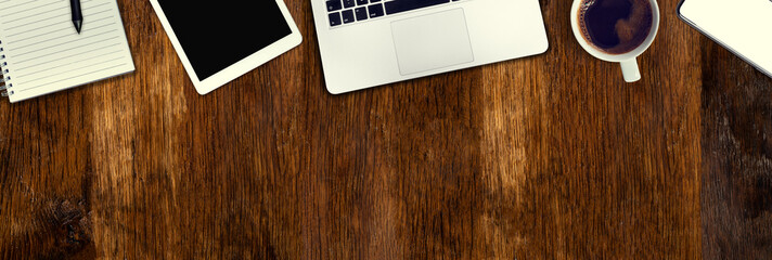 Old oak desk from above. Computer, telephone and tablet necessary tools at work. Office work in vintage style. Wide banner with copy space.