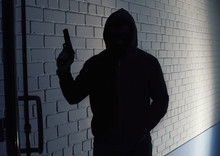 Silhouette Of Man With Gun In Hoodie Indoors. Dangerous Criminal