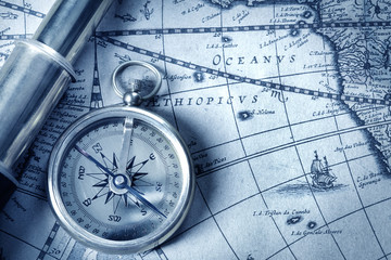 compass and spyglass on medieval map