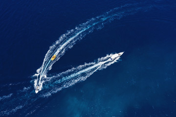 Canvas Print - Yachts at the sea surface. Aerial view of luxury floating boat on transparent turquoise water at sunny day. Top view from drone. Seascape with motorboat in bay. Travel - image