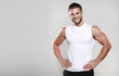 © KDdesignphoto - Muscular model man in white t-shirt on a gray background. Sporty guy showing his big shoulders,biceps, triceps. Workout, bodybuilding, Shirt design, people concept. Mock up template for design print.