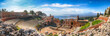 Ruins of ancient Greek theater in Taormina and Etna volcano in the background.