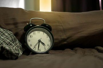 Vintage alarm clock on vintage bed