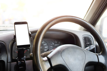 Wall Mural - cropped shot view the driver uses the phone while driving. modern smart phone with round edges. isol