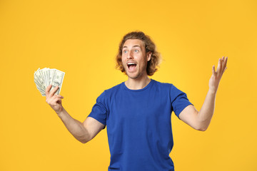 Happy man with money on color background