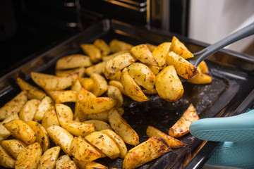 Wall Mural - Golden oven-baked potatoes with oil and spices