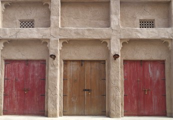 Old house front with three colored wooden doors, unique atmosphere.