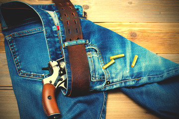 Wall Mural - revolver nagant with cartridges in old blue jeans