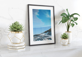 Wall Mural - Black frame leaning on white shelve in bright interior with plants and decorations mockup 3D rendering