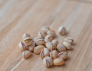 Roasted pistachios on natural wooden table background